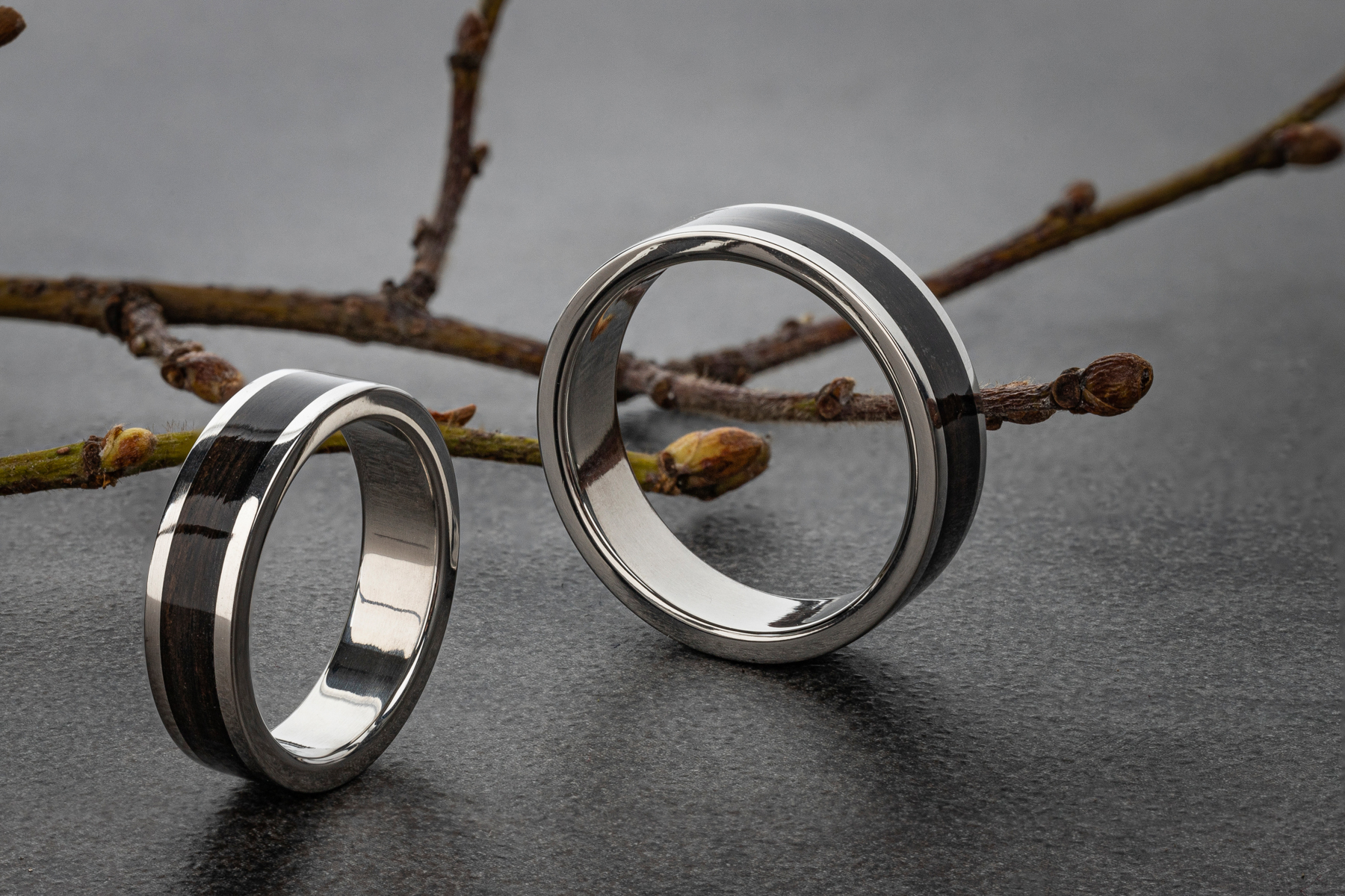 Obrączki z metalu i drewna. Rolą kreatywnych zdjęć produktowych jest tutaj zbudowanie skojarzeń z naturą.